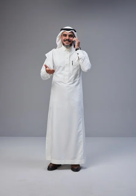 Saudi Man in Traditional Dress Talking on Smartphone