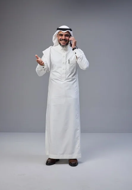 رجل سعودي بالزي التقليدي يتحدث عبر الهاتف الجوال