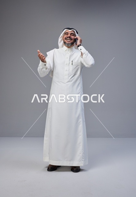 رجل سعودي بالزي التقليدي يتحدث عبر الهاتف الجوال
