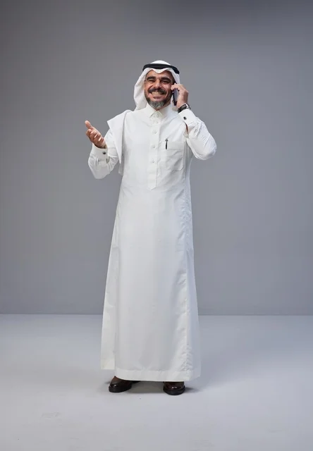 رجل سعودي بالزي التقليدي يتحدث عبر الهاتف المحمول