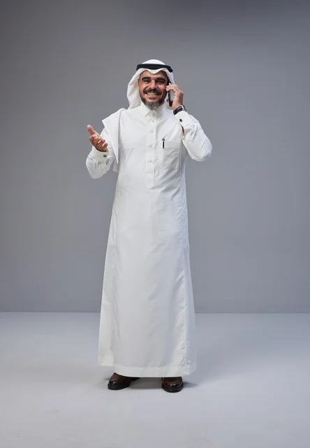 رجل سعودي بالزي التقليدي يتحدث بالهاتف المحمول