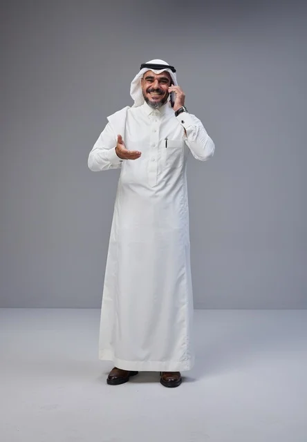 رجل سعودي بالزي التقليدي يتحدث عبر الهاتف الجوال