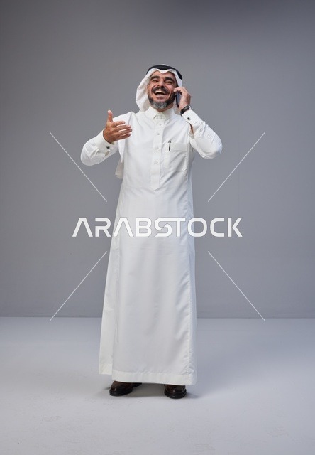 رجل سعودي بالزي التقليدي يتحدث عبر الهاتف الجوال