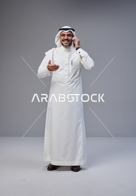 رجل سعودي بالزي التقليدي يتحدث عبر الهاتف المحمول
