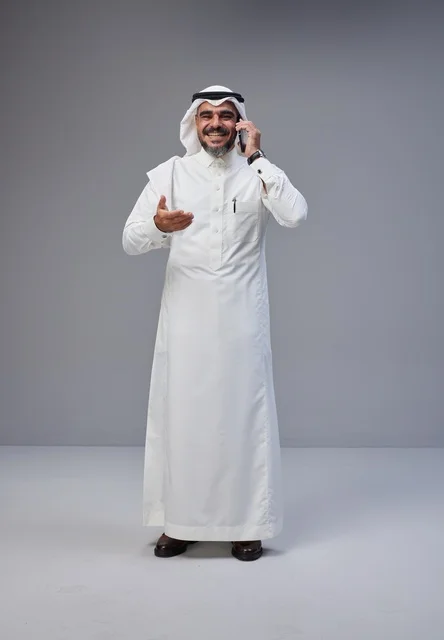 رجل سعودي بالزي التقليدي يتحدث عبر الهاتف المحمول