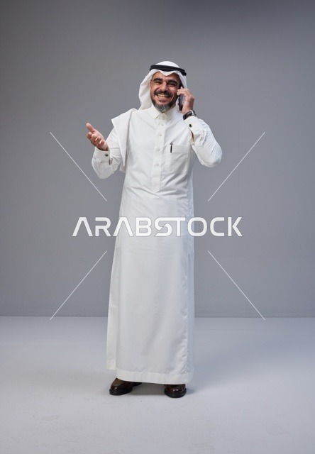 Saudi Man in Traditional Thobe Talking on Smartphone