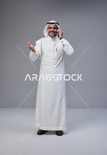 رجل سعودي بالزي التقليدي يتحدث عبر الهاتف المحمول