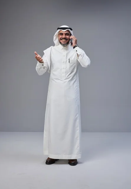 Saudi Man in Traditional Thobe Talking on Mobile Phone