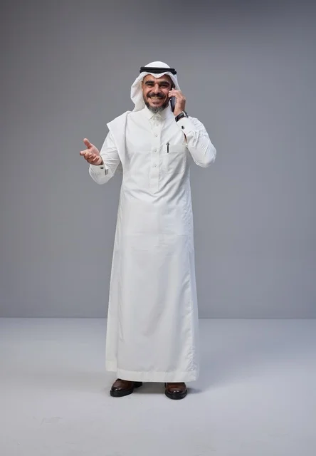 رجل سعودي بالزي التقليدي يتحدث عبر الهاتف الجوال