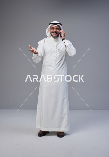 رجل سعودي بالزي التقليدي يتحدث عبر الهاتف المحمول