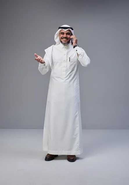رجل سعودي بالزي التقليدي يتحدث عبر الهاتف المحمول