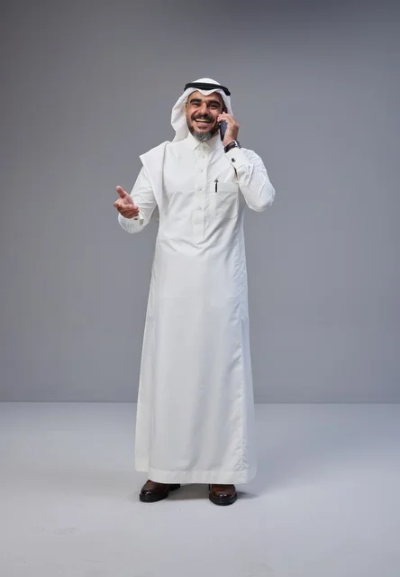 رجل سعودي بالزي التقليدي يتحدث عبر الهاتف المحمول