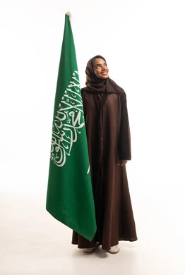 امرأة سعودية تحمل العلم السعودي في الاستوديو