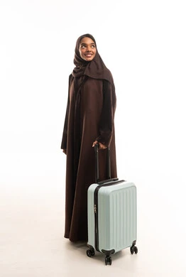 Saudi Woman in Brown Abaya with Suitcase on White
