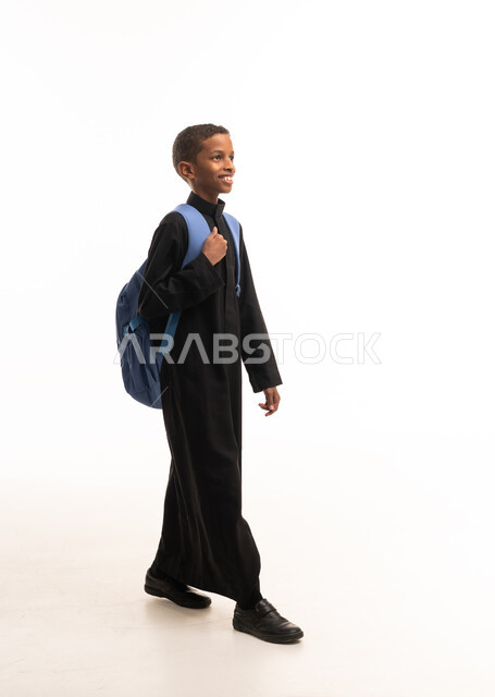 طفل سعودي بالثوب الأسود مع حقيبة مدرسية