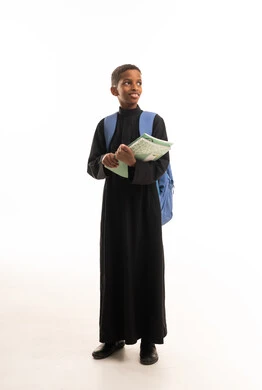 طالب أفريقي بالثوب الأسود مع حقيبة مدرسية