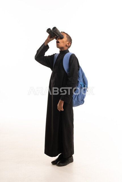 طفل سعودي بالثوب الأسود يحمل منظاراً