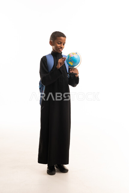 طالب سعودي بالثوب الأسود يحمل مجسم الكرة الأرضية
