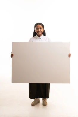 طالبة سعودية تحمل لوحة بيضاء فارغة في الاستوديو
