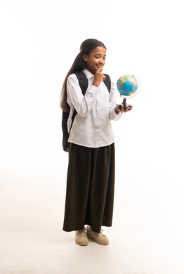 طالبة سعودية تحمل مجسم الكرة الأرضية بخلفية بيضاء