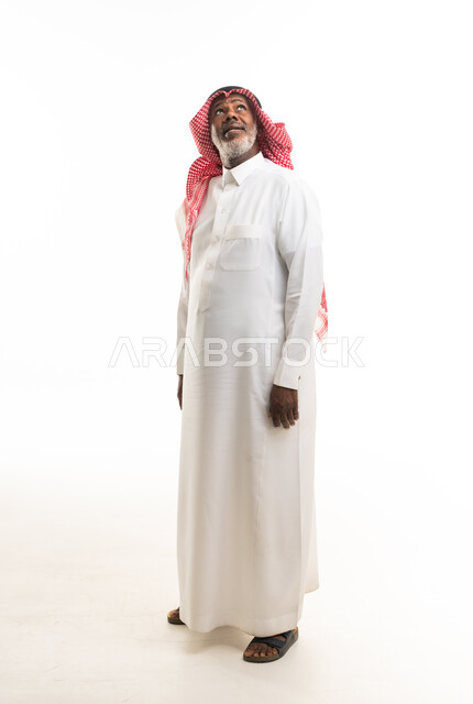 رجل سعودي مسن يرتدي الثوب التقليدي وينظر للأعلى