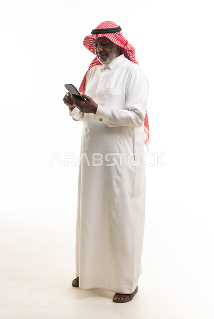 رجل سعودي مسن يستخدم الهاتف الذكي في الاستوديو