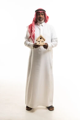 Saudi Senior Man Holding Wooden House Model