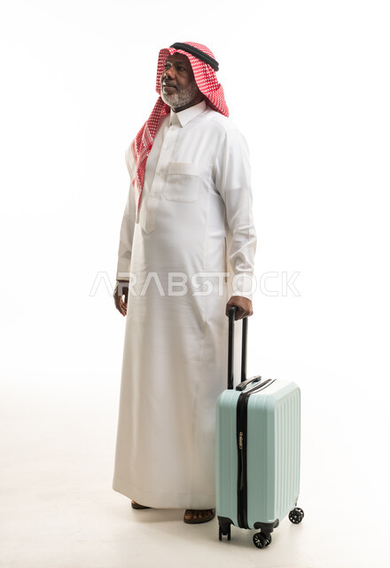 رجل سعودي مسن مع حقيبة سفر بخلفية بيضاء