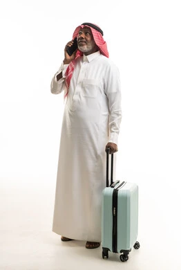 Senior Saudi Man with Suitcase Talking on Phone