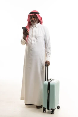 رجل سعودي مسن مع حقيبة سفر وهاتف ذكي