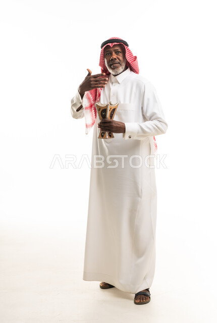 رجل سعودي مسن يحمل مبخرة بخور خشبية تقليدية