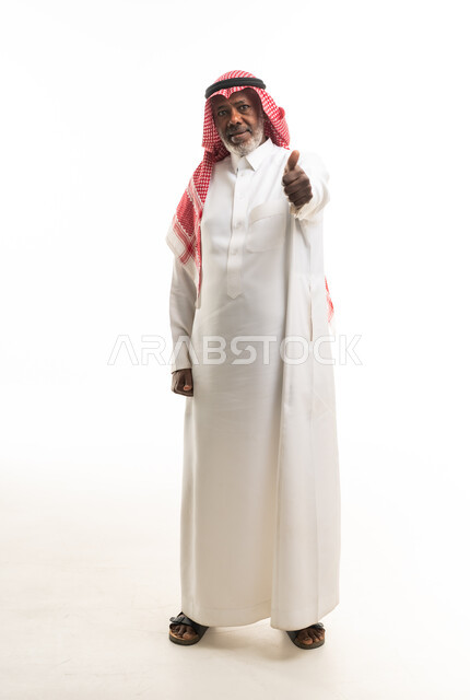 رجل سعودي مسن بالزي التقليدي يشير بالإبهام