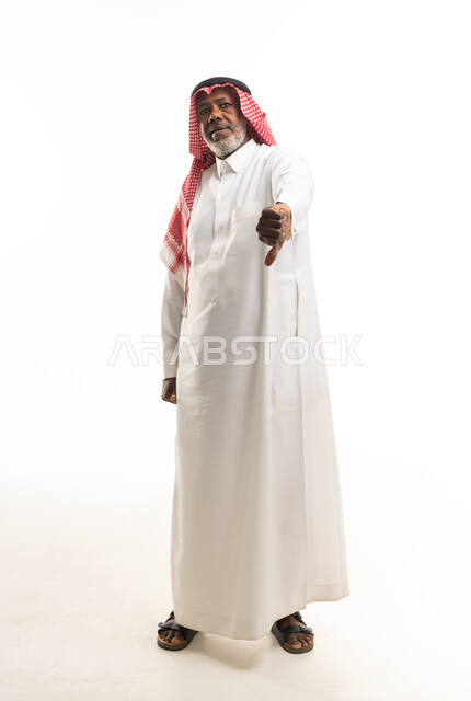 رجل سعودي مسن يشير بعدم الإعجاب باللباس التقليدي