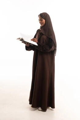 Saudi Woman in Brown Abaya Reading Book on White Background