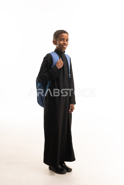 طالب سعودي بالثوب الأسود يحمل حقيبة مدرسية