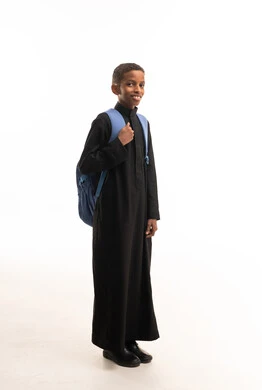 طالب سعودي بالثوب الأسود يحمل حقيبة مدرسية