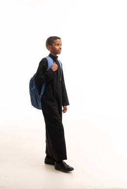 طالب سوداني بالثوب الأسود مع حقيبة مدرسية