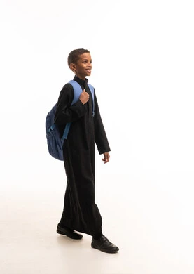 طالب سعودي بالثوب الأسود مع حقيبة مدرسية زرقاء