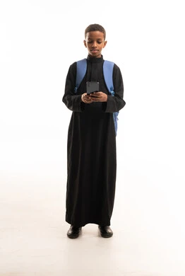 طالب سعودي بالثوب الأسود يستخدم الهاتف الذكي