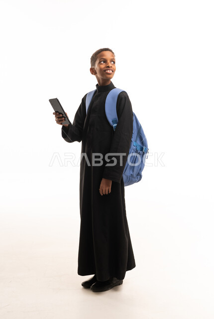 صبي سوداني بالثوب يحمل هاتف ذكي وحقيبة ظهر