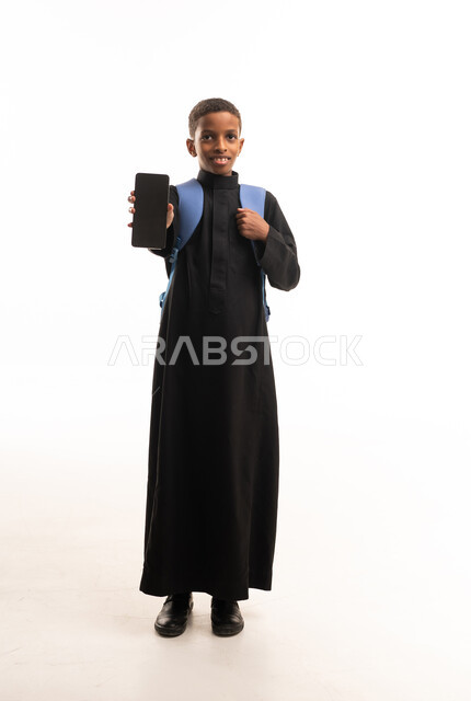 طالب سعودي بالثوب الأسود يحمل هاتف ذكي