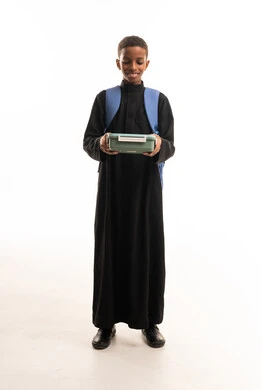 طالب سعودي بالثوب الأسود يحمل صندوق غداء مدرسي