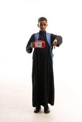 طالب سعودي يحمل ساعة منبه مع إشارة الرفض