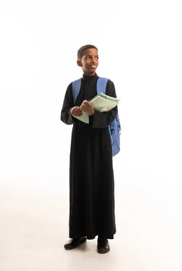 طالب سعودي بالثوب الأسود مع حقيبة مدرسية