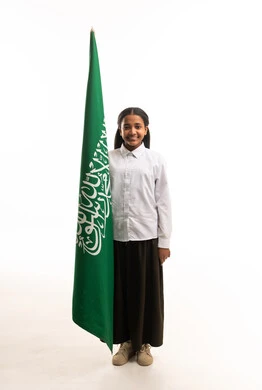 طالبة سعودية بالزي المدرسي تمسك علم المملكة