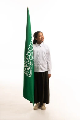 طالبة سعودية مع العلم السعودي في الاستوديو