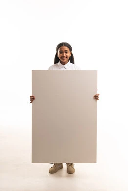 طالبة سعودية تمسك لوحة بيضاء فارغة في الاستوديو