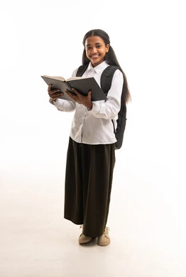 طالبة سعودية تمسك كتاباً مع حقيبة مدرسية
