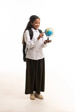 طالبة سعودية بالزي المدرسي تحمل مجسم الكرة الأرضية