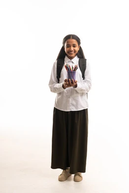 طالبة سعودية بالزي المدرسي مع حقيبة وأقلام ملونة